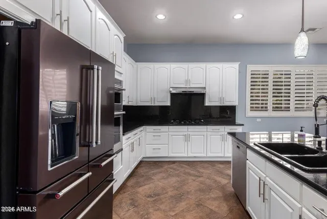 a kitchen with stainless steel appliances a sink stove and cabinets