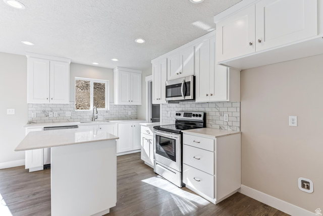 257 North Slant Road, Unit 51M Mapleton, UT 84660 - Photo 4 of 24 Kitchen with stainless steel appliances, white cabinets, a kitchen island, light stone counters, and dark wood-type flooring