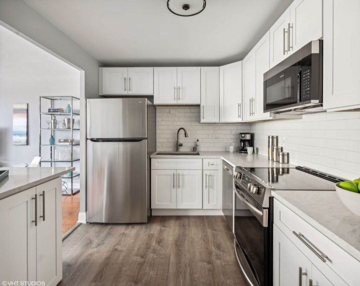 6301 North Sheridan Road, Unit 19D Chicago, IL 60660 - Photo 7 of 11 a kitchen with a sink a refrigerator a microwave and cabinets
