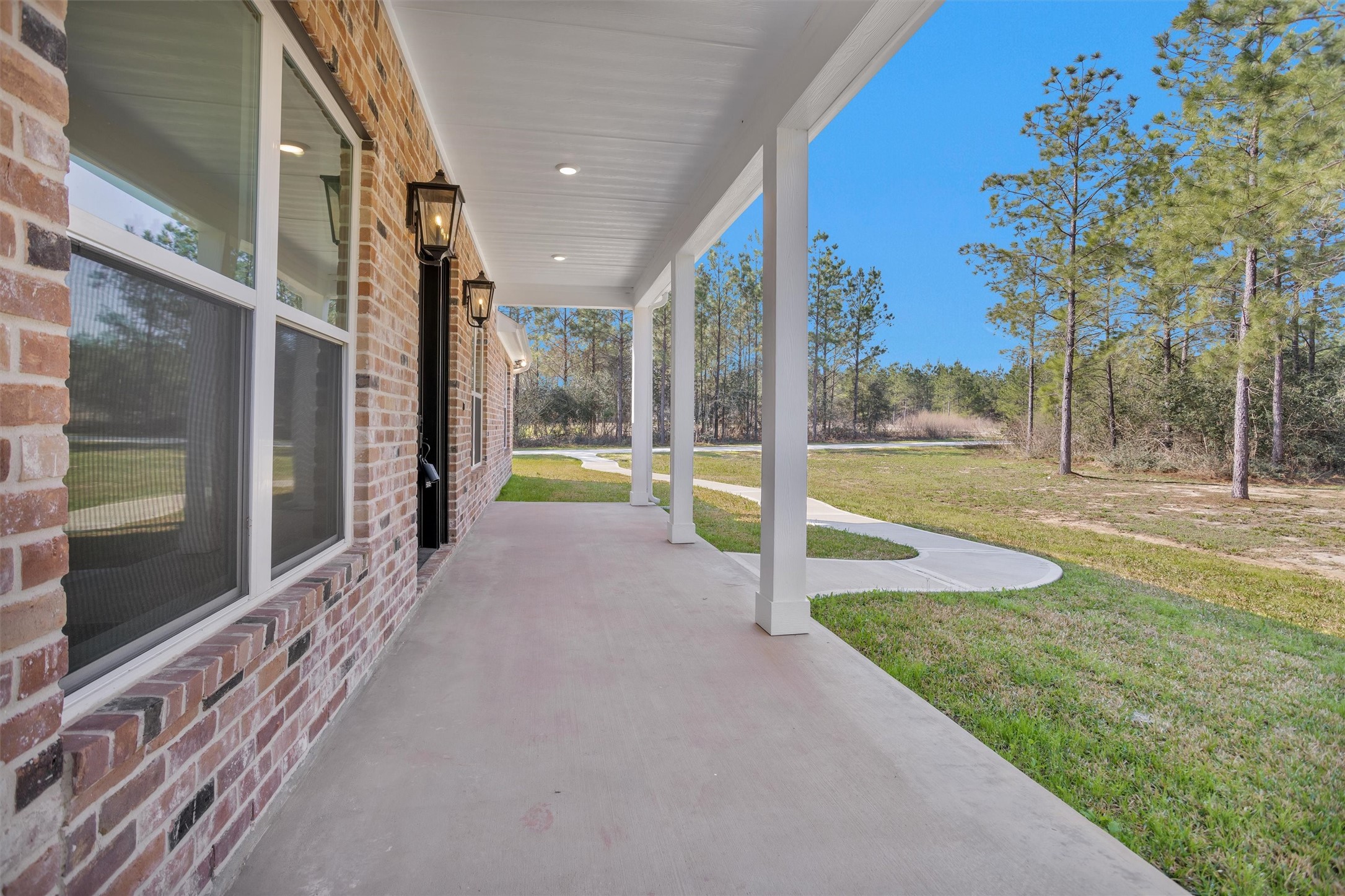 12744 Oak Barrel Road Willis, TX 77378 - Photo 5 of 50 This beautiful brick home welcomes you with an expansive front patio designed for both relaxing and entertaining. The oversized front door creates a grand entrance and sets the tone for the impressive interior that awaits. From the moment you step onto the spacious patio, you’ll appreciate the inviting curb appeal and thoughtful design.