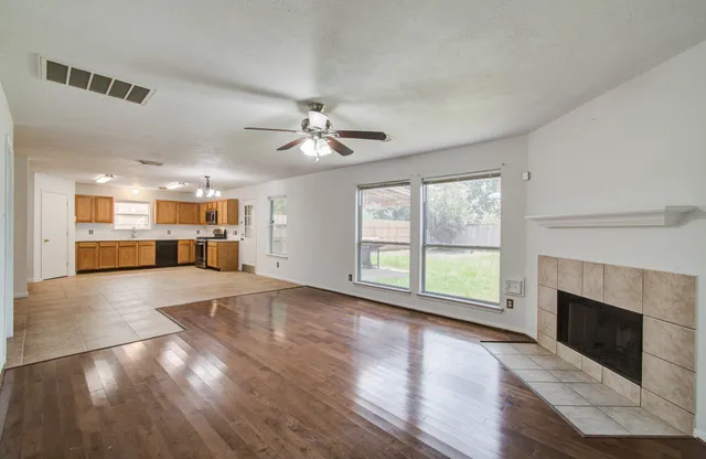 a view of an empty room with a fireplace and a window