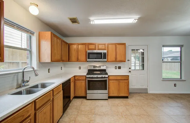 a kitchen with stainless steel appliances a stove sink and microwave