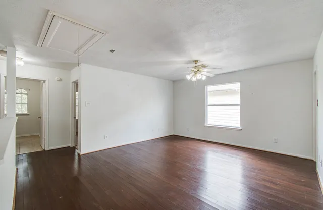 a view of a livingroom with wooden floor and a ceiling fan