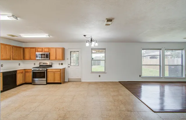 a large kitchen with a large window and stainless steel appliances