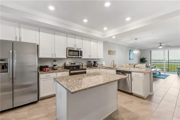 a kitchen with a sink a counter top space stainless steel appliances and cabinets