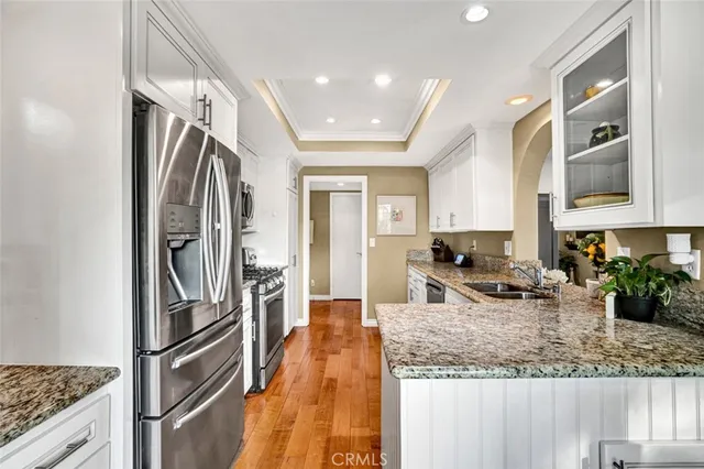 a kitchen with stainless steel appliances granite countertop a refrigerator a stove and a sink