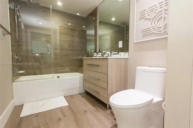a bathroom with a bathtub shower sink mirror and toilet