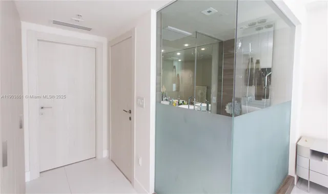 a bathroom with a glass shower door and a mirror