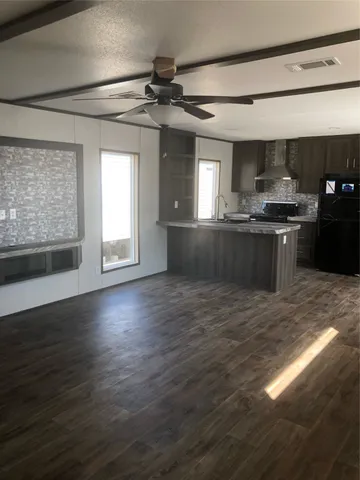 a kitchen with granite countertop a stove and a wooden floors