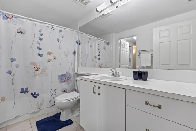 a bathroom with a granite countertop sink toilet and a mirror