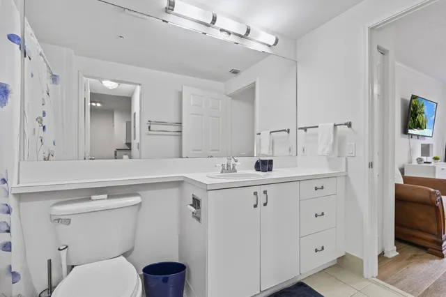 a spacious bathroom with a granite countertop toilet sink and a mirror