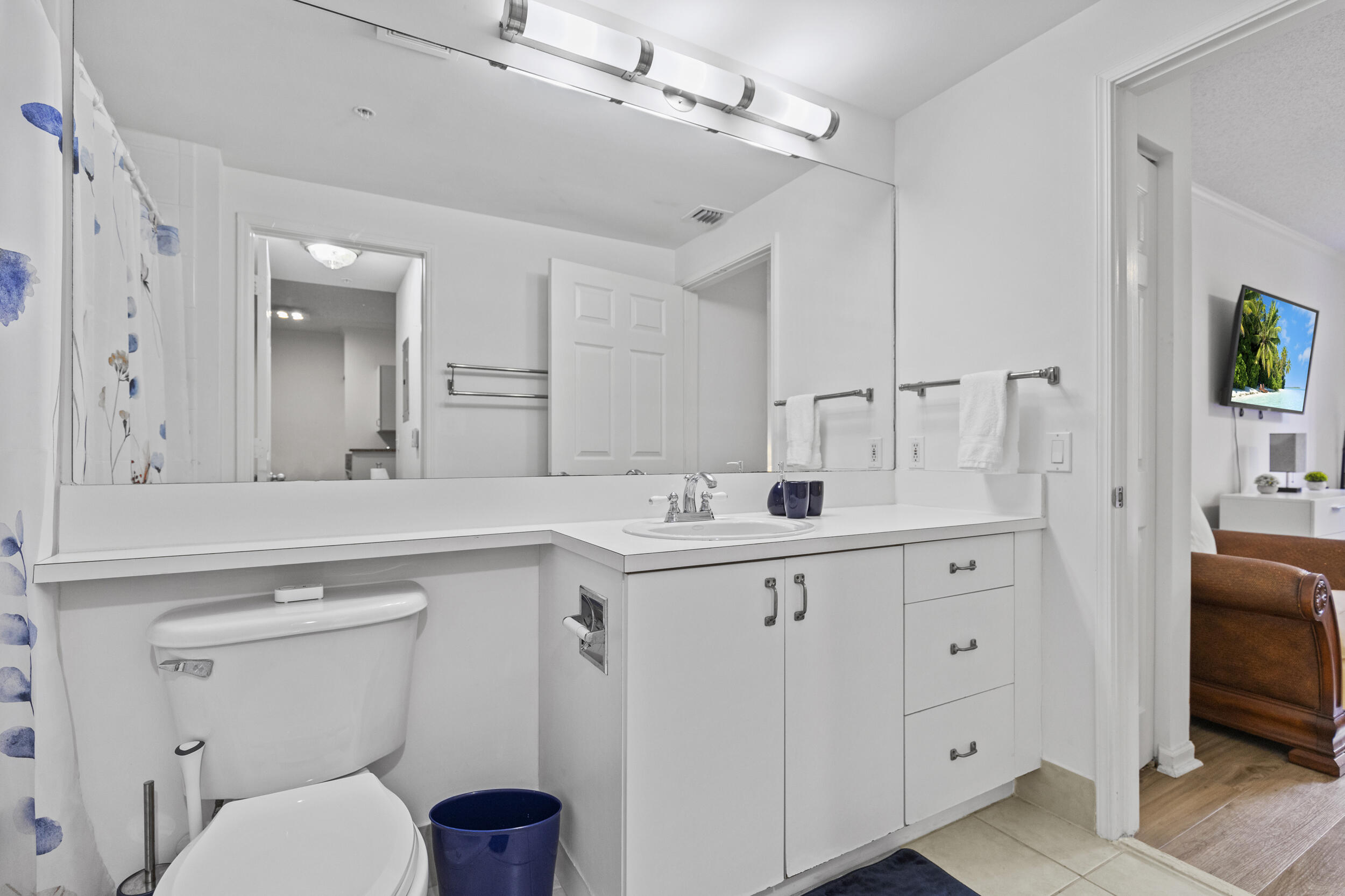 630 South Sapodilla Avenue, Unit 202 West Palm Beach, FL 33401 - Photo 16 of 31 a spacious bathroom with a granite countertop toilet sink and a mirror