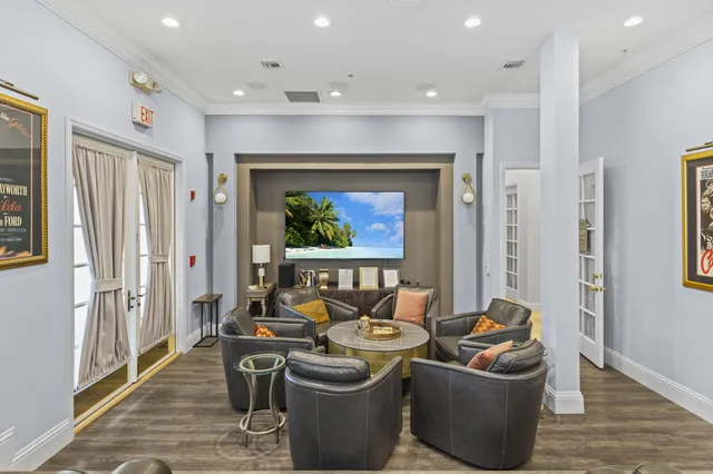 a room with stainless steel appliances a dining table wooden floor and a large window