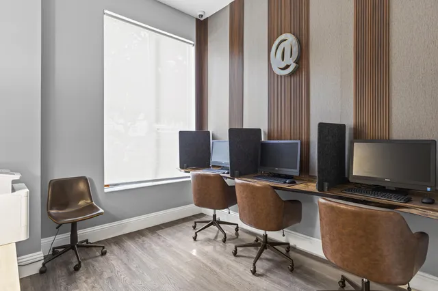 a view of a workspace with furniture and a window