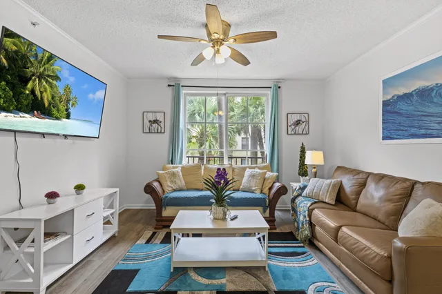 a living room with furniture a flat screen tv and a large window