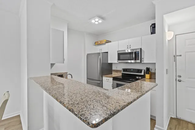 a kitchen with kitchen island granite countertop a sink stove and refrigerator