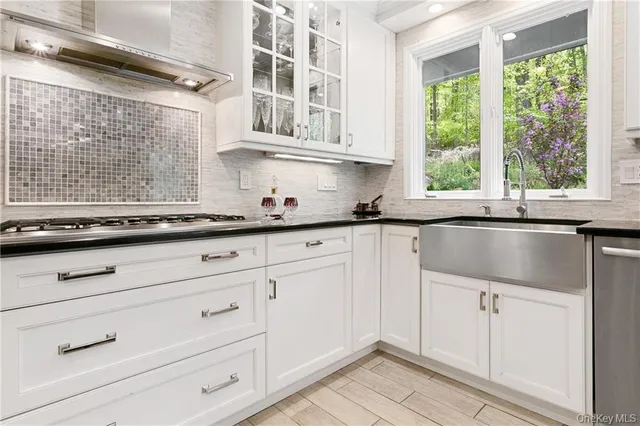 a kitchen with granite countertop white cabinets and a window