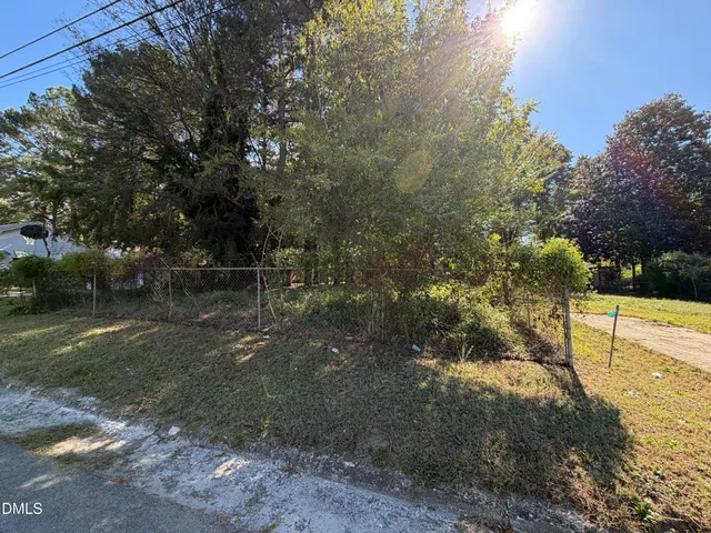 a view of a yard with plants and trees