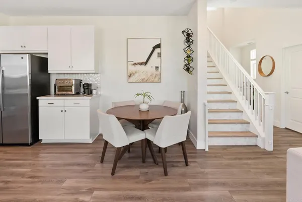 a kitchen with a dining table chairs sink and cabinets