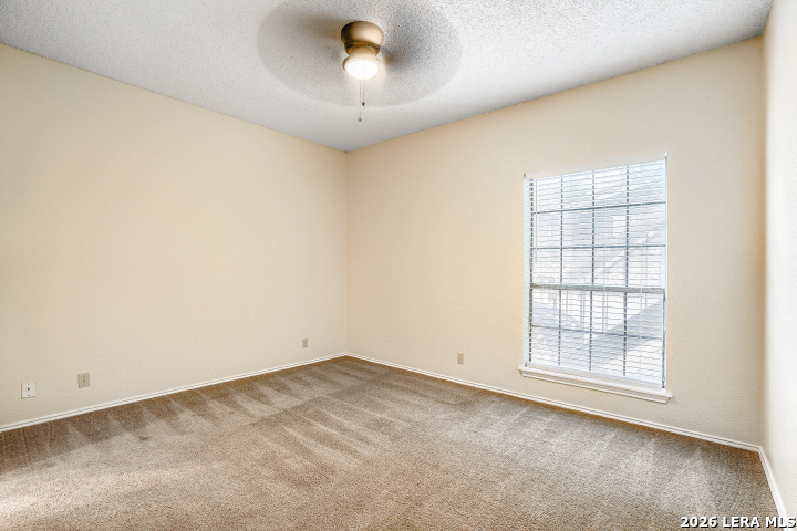 8655 Datapoint, Unit 403 San Antonio, TX 78229 - Photo 13 of 22 an empty room with a chandelier fan and windows