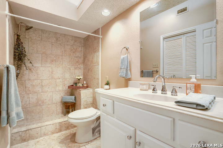 8655 Datapoint, Unit 403 San Antonio, TX 78229 - Photo 17 of 22 a bathroom with a sink a toilet and shower