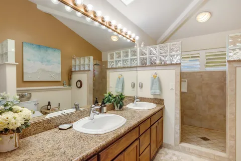 a bathroom with double vanity and a mirror
