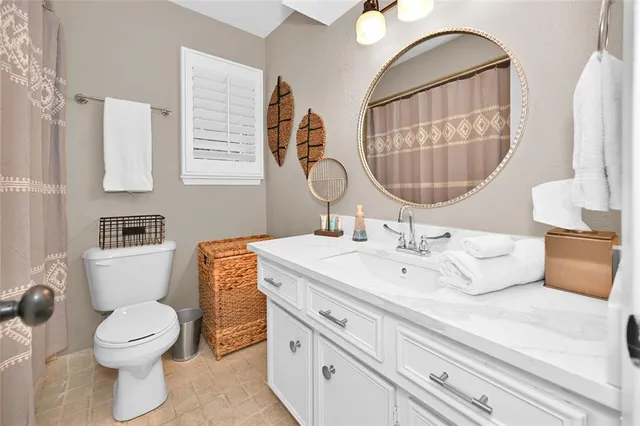 a bathroom with a toilet sink and mirror