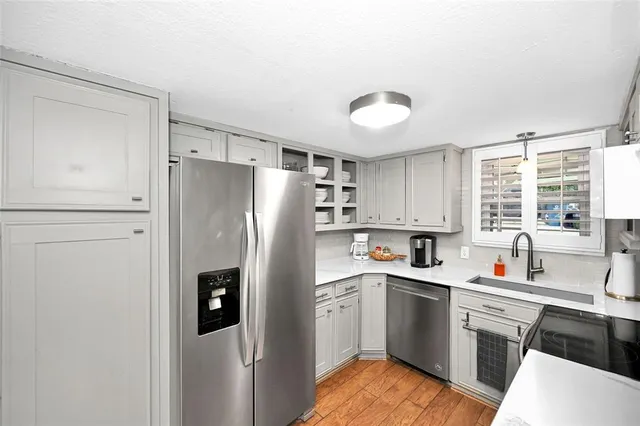 a kitchen with a refrigerator sink and cabinets