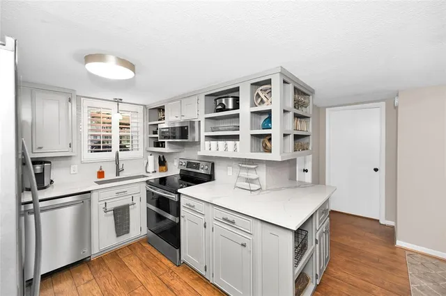 a kitchen that has a lot of cabinets in it and wooden floors