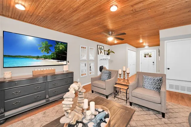 a living room with couches bookshelf and a flat screen tv