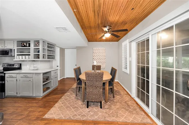 a view of a dining room with furniture a rug and wooden floor