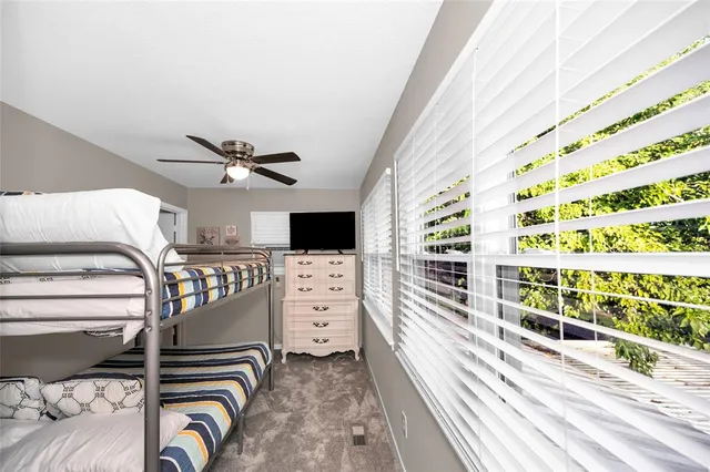 a view of a bedroom with wooden floor & windows