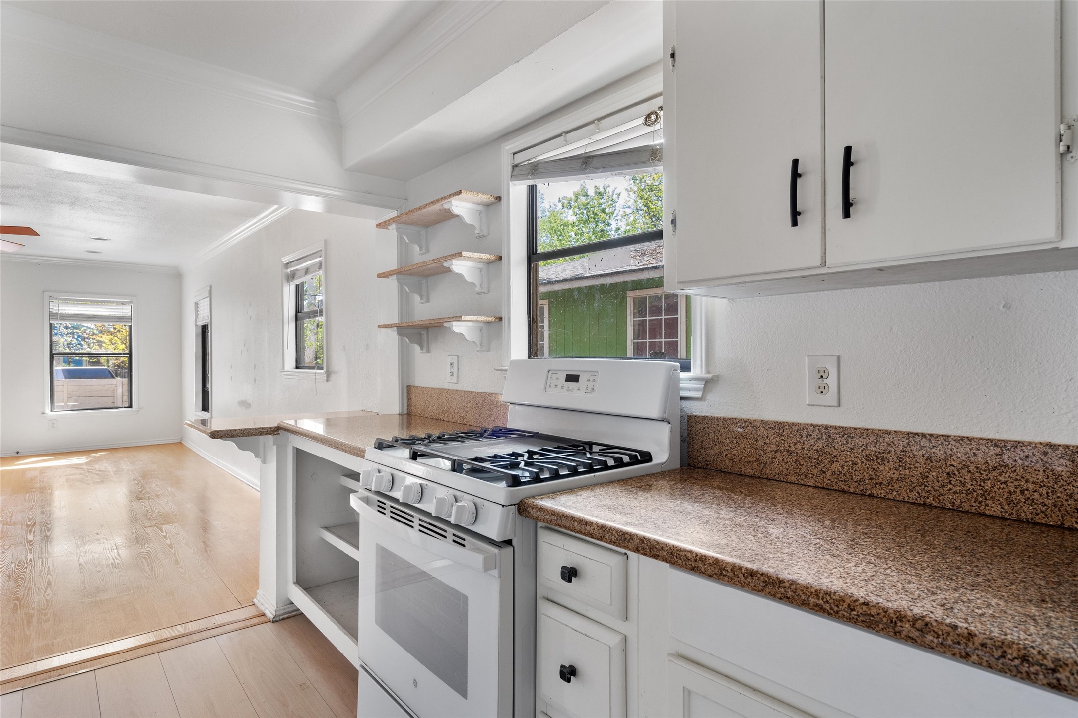 2710 East 3rd Street Austin, TX 78702 - Photo 6 of 28 a kitchen with granite countertop a sink stove and cabinets