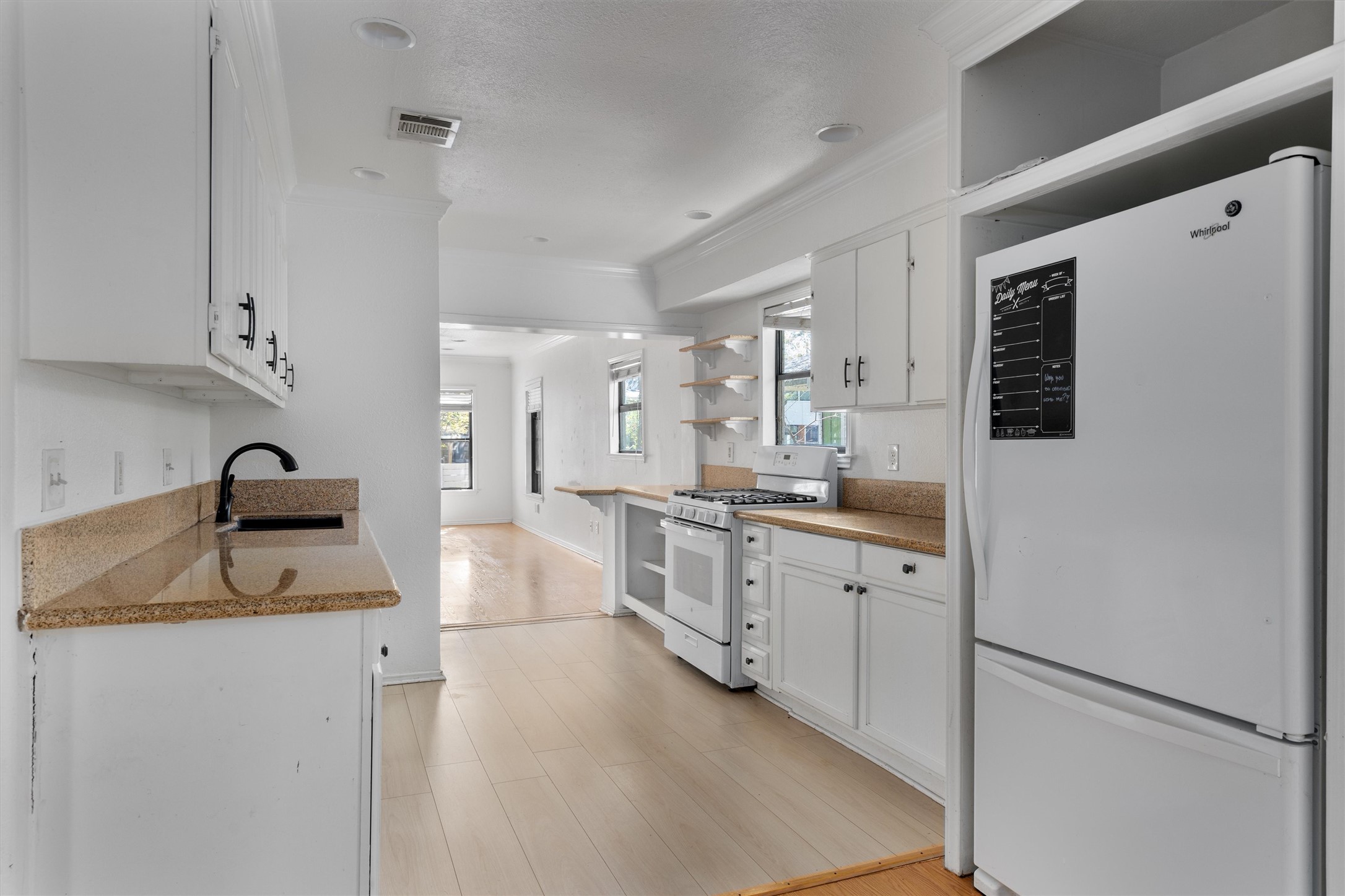 2710 East 3rd Street Austin, TX 78702 - Photo 9 of 28 a kitchen with sink refrigerator and cabinets