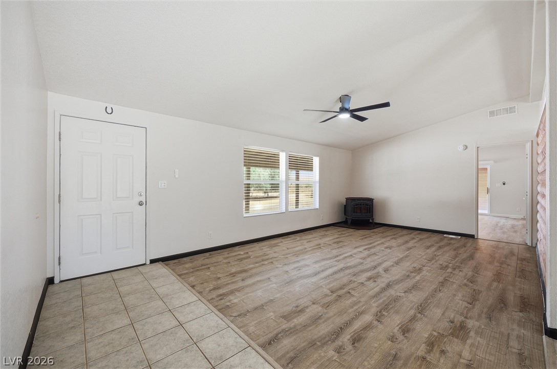 1531 West Harris Farm Road Pahrump, NV 89060 - Photo 18 of 37 A comfortable living space featuring wood-look flooring and a cozy corner stove.
