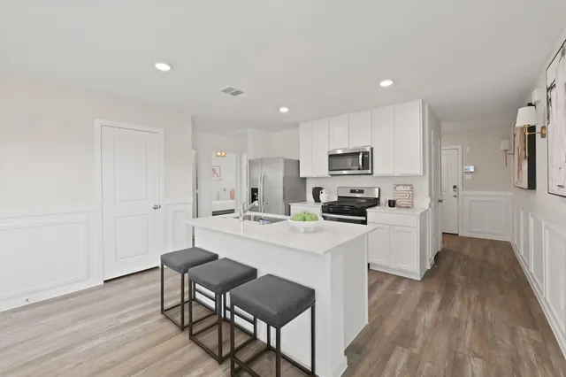 a kitchen with white cabinets and stainless steel appliances