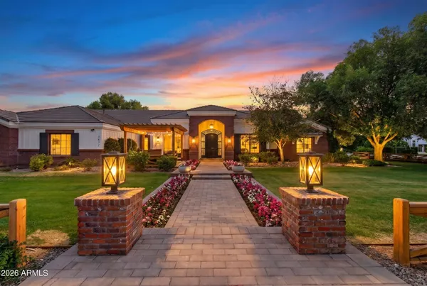 a view of a house with a big yard plants and large trees