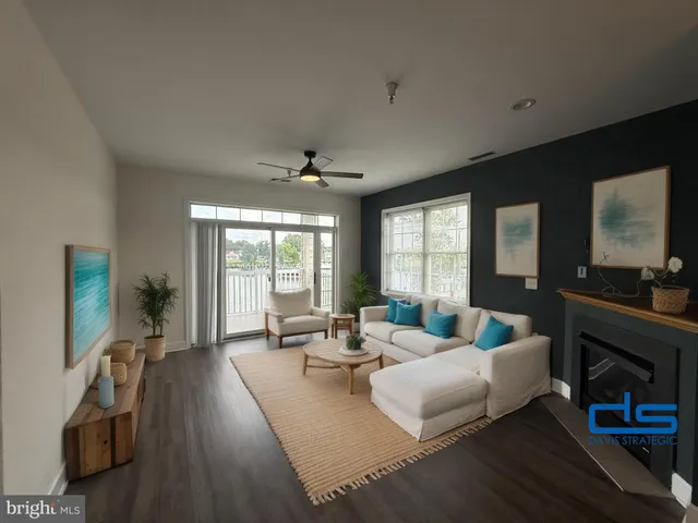 a living room with furniture large window and wooden floor