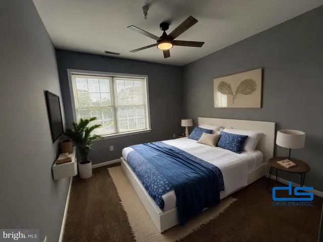 a bedroom with a large bed and a potted plant