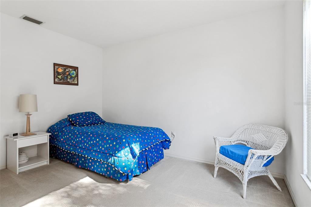 9016 Easthaven Court New Port Richey, FL 34655 - Photo 17 of 38 a bedroom with a bed and a chair