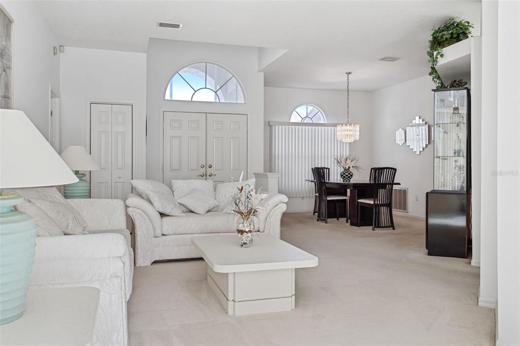 9016 Easthaven Court New Port Richey, FL 34655 - Photo 6 of 38 a living room with furniture a dining table and chairs with white walls