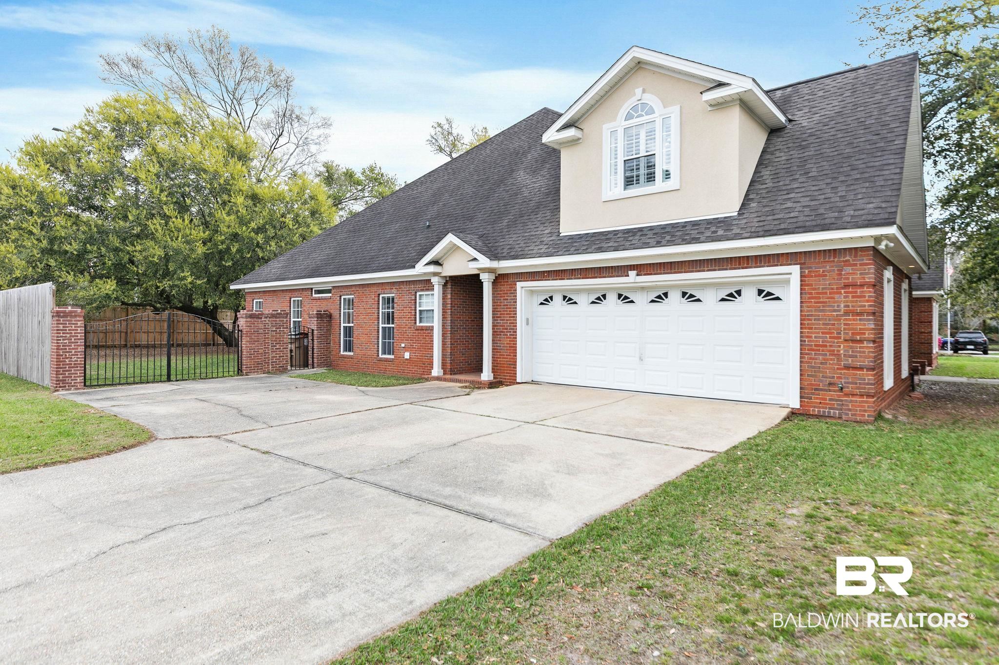 3668 Claridge Road North Mobile, AL 36608 - Photo 13 of 100 View of front facade with driveway, brick siding, a gate, and a garage
