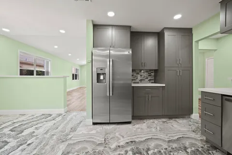 a kitchen with stainless steel appliances granite countertop a stove a sink and a refrigerator