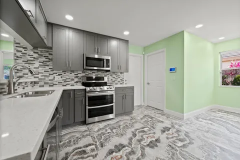a kitchen with white cabinets stainless steel appliances and sink