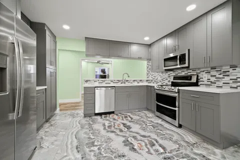 a kitchen with stainless steel appliances granite countertop a sink stove and refrigerator