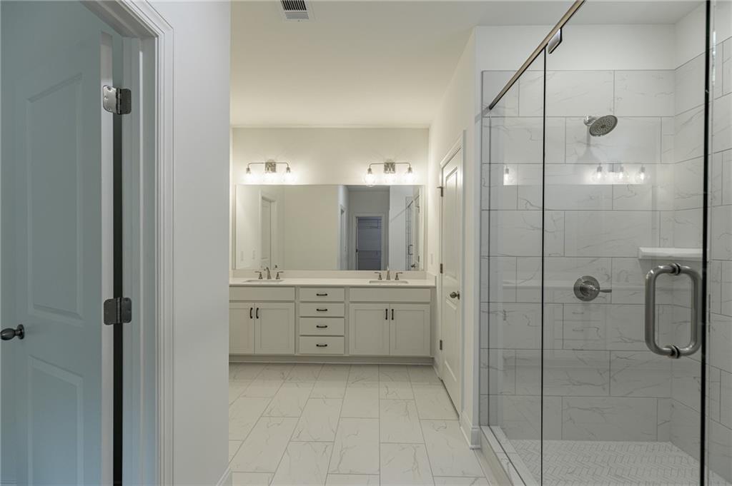 1210 Austin Road Winder, GA 30680 - Photo 36 of 56 a bathroom with a shower sink and mirror