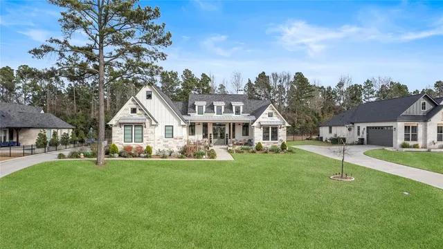a front view of a house with a yard and trees