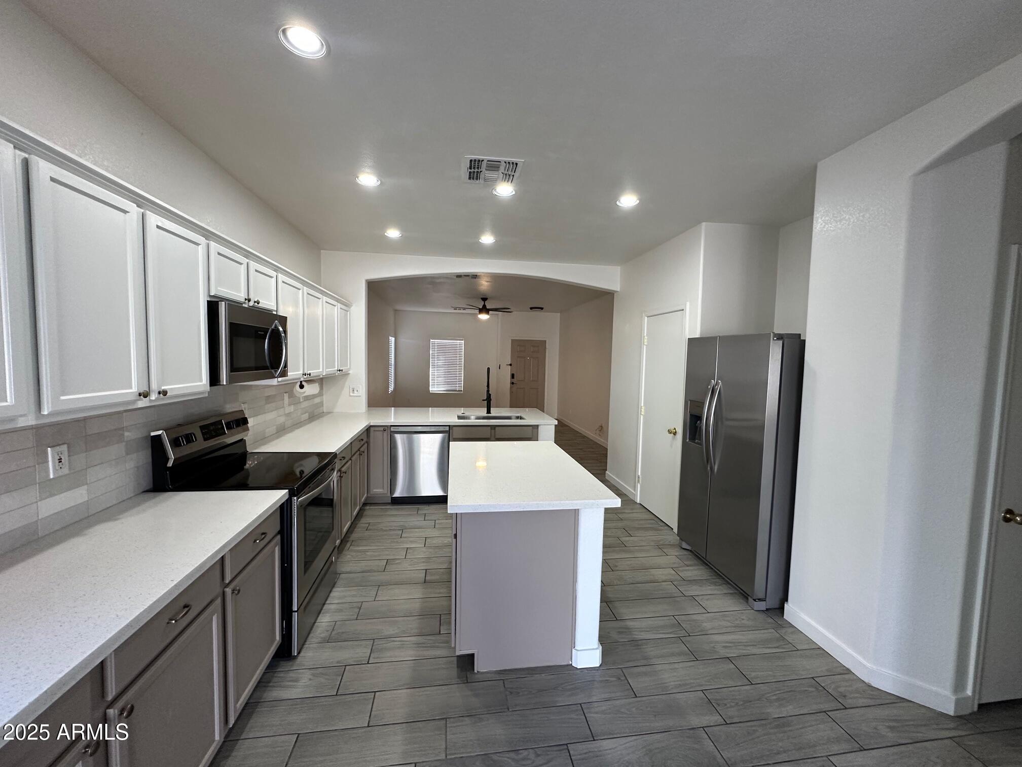 2767 South Sailors Way Gilbert, AZ 85295 - Photo 11 of 15 a large kitchen with stainless steel appliances kitchen island granite countertop a large counter top a refrigerator and a sink