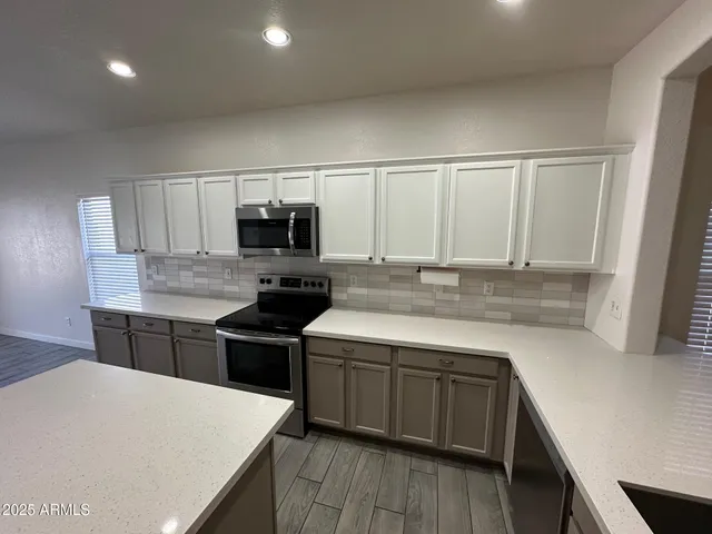 a kitchen with a sink and a stove top oven with wooden floor
