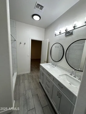 a bathroom with a double vanity sink and a mirror